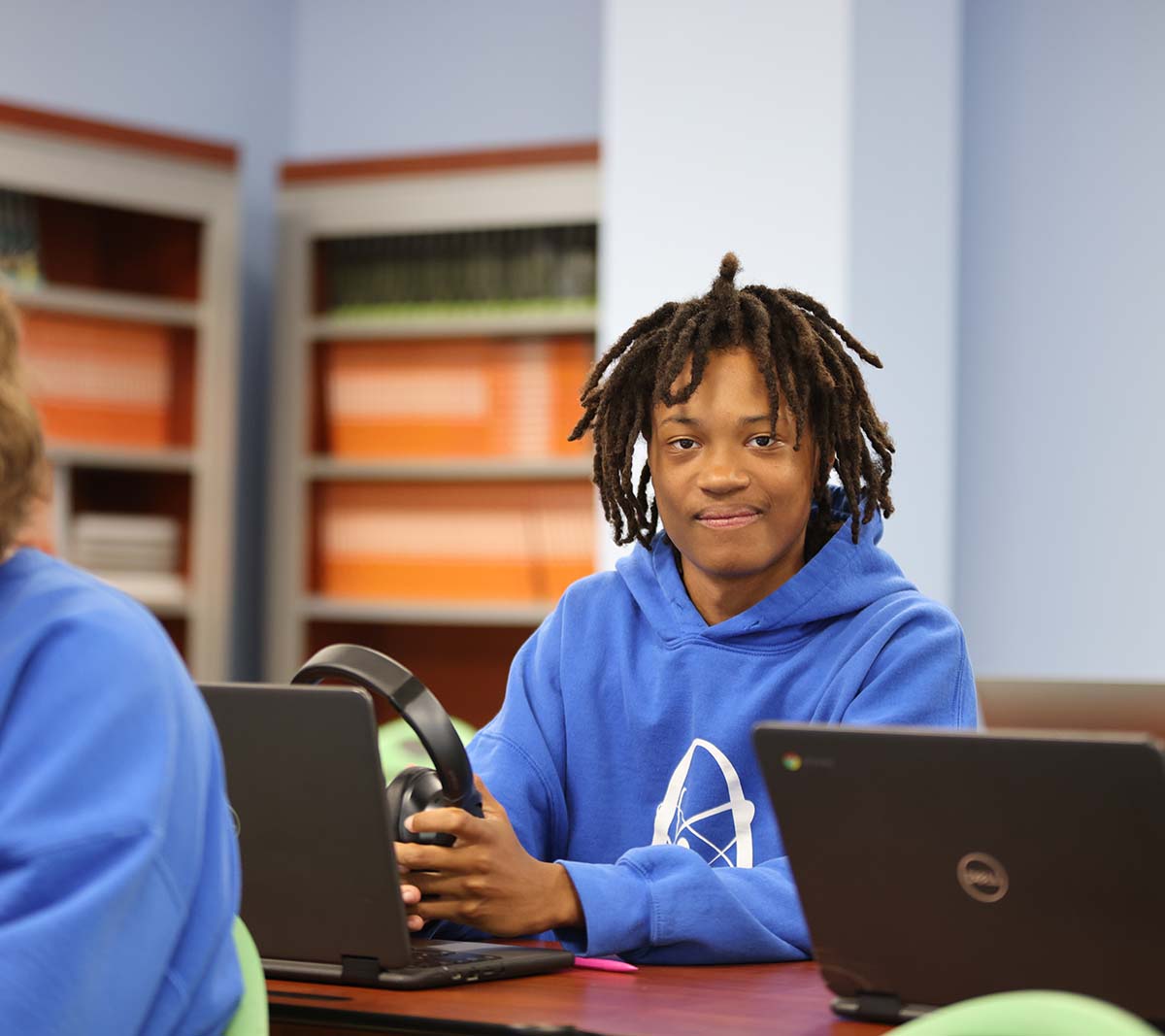 Student working on a notebook in a classroom.